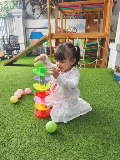 Anak-anak bermain di area rumput sekolah